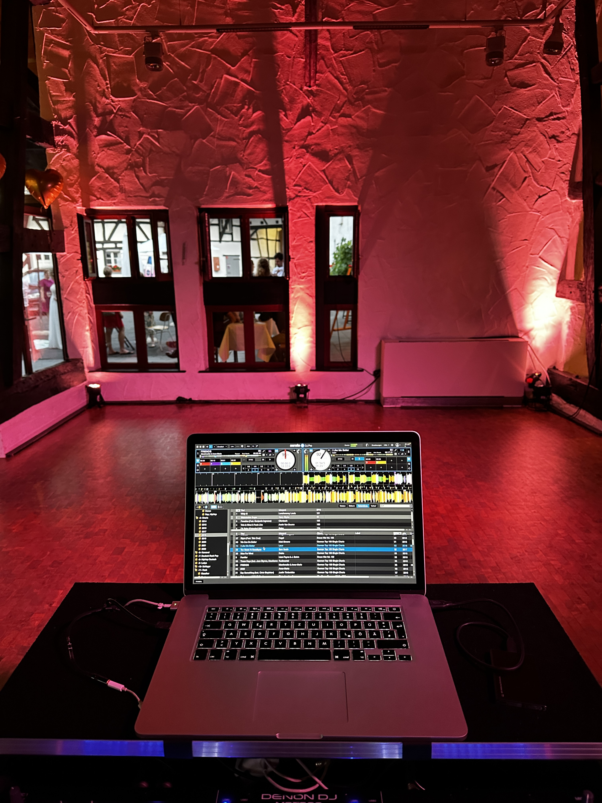 Blick über das DJ Pult auf die beleuchtete Tanzfläche