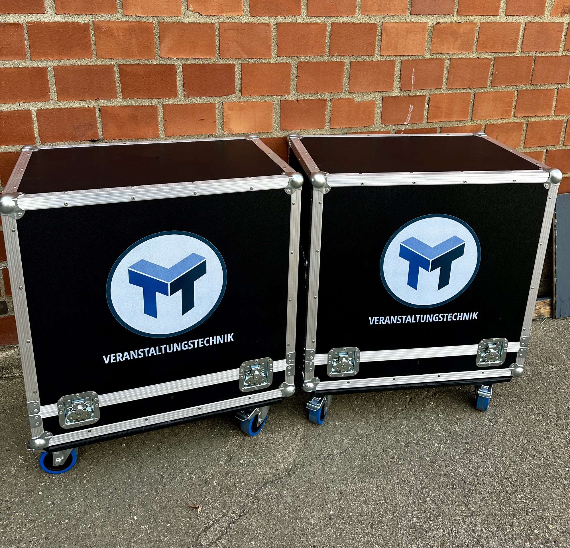 Foto von zwei Cases vor Backsteinwand