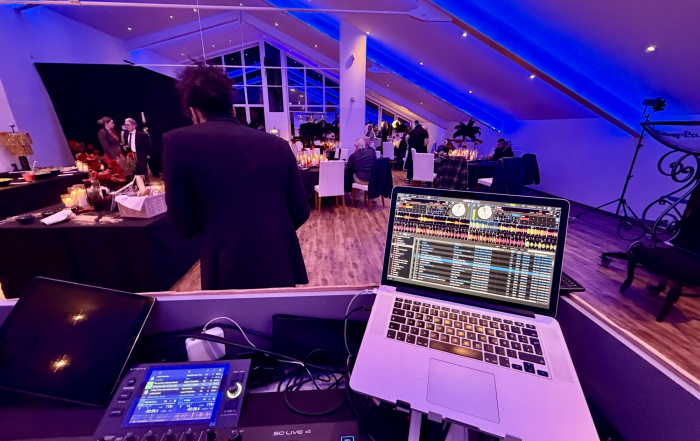 Blick über das DJ Pult und Saxophonisten in den Saal