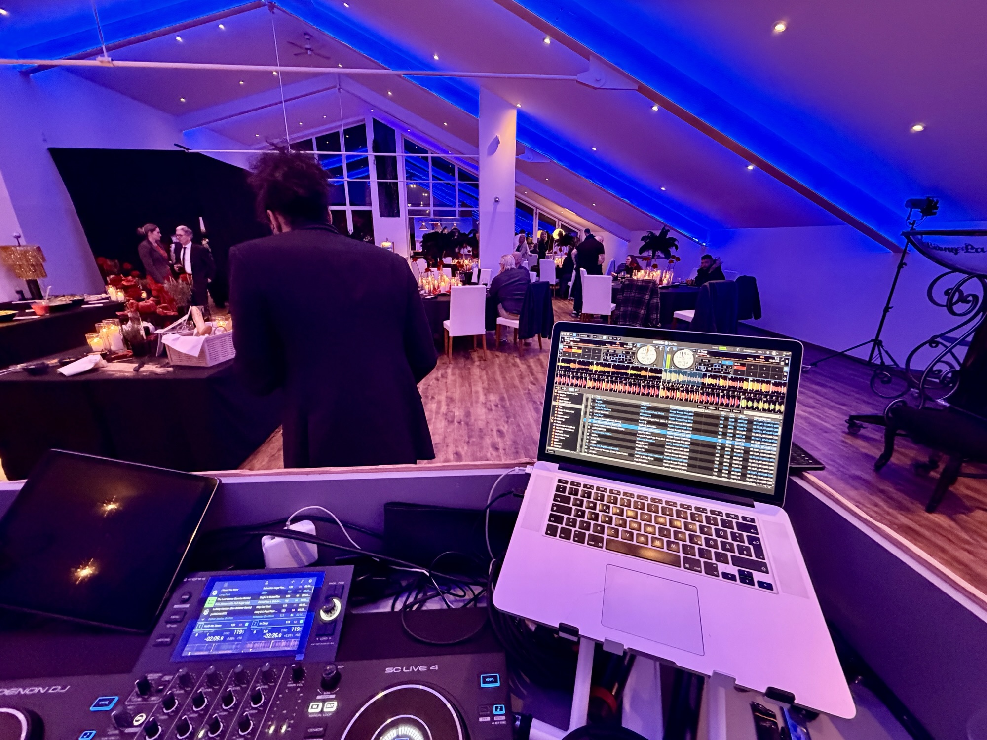 Blick über das DJ Pult und Saxophonisten in den Saal