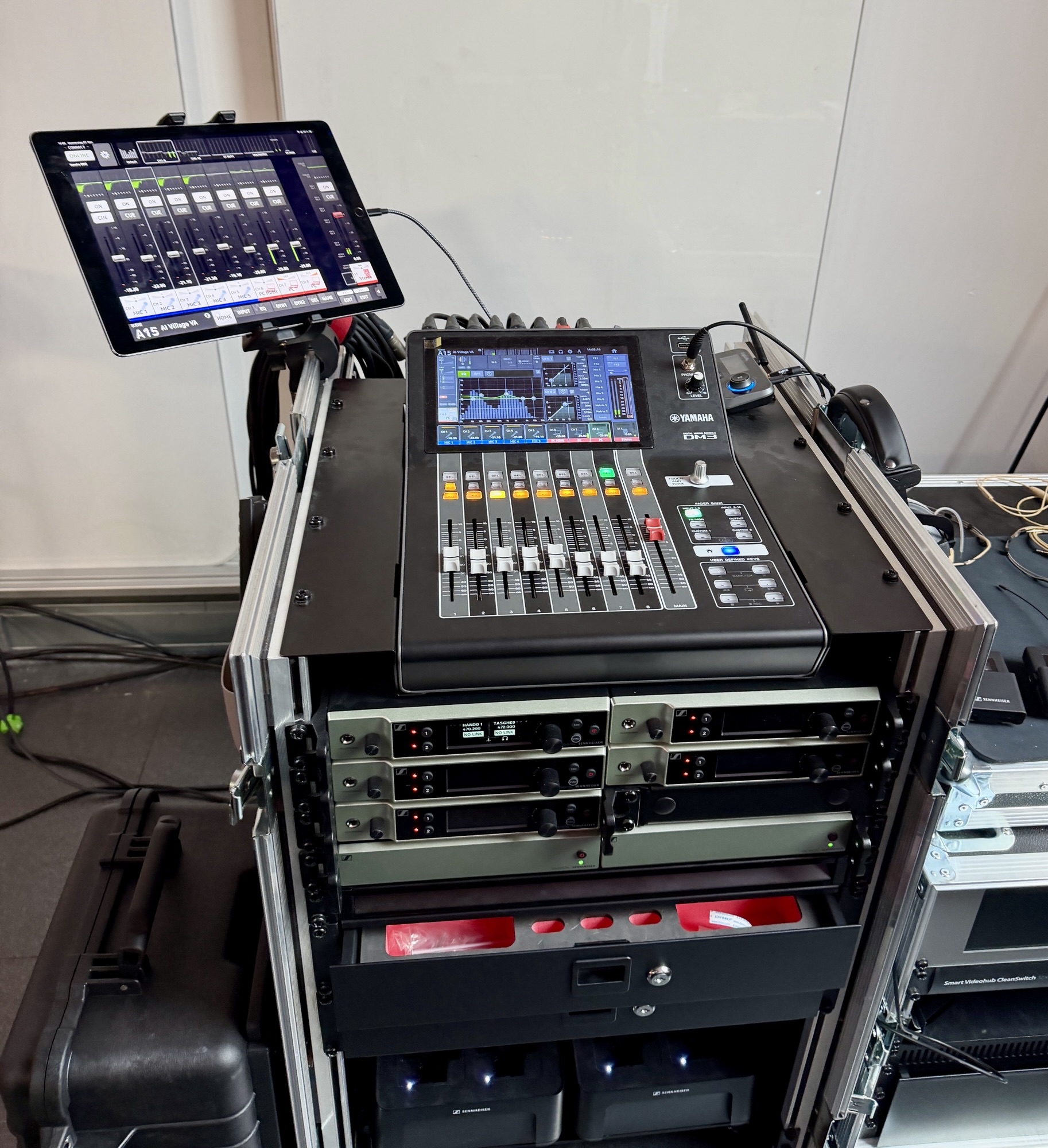 Yamaha-DM3-Digitalmixer mit iPad als Fernbedienung, darunter ein Rack mit mehreren Sennheiser-Funkempfängern
